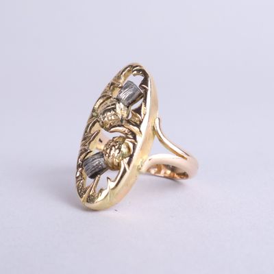 une image d'un gros plan d'une bague en or sur une surface blanche