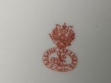 a close up of a white plate with a red emblem on it