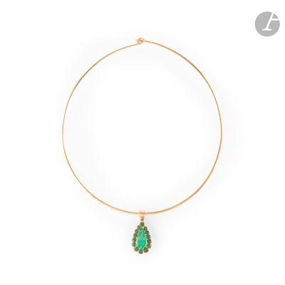 a gold necklace with a green stone pendant on a white background