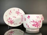 une tasse et une soucoupe roses et blanches posées sur une table