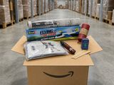 une boîte en carton remplie de fournitures posée à même le sol d'un entrepôt