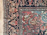 an antique rug with a blue and red design on a beige background