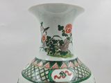 a white vase with a green and red design on it