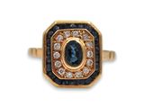 un gros plan d'une bague en or sertie d'un saphir bleu et de diamants blancs
