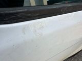 a white car that has a broken door handle on the side of it
