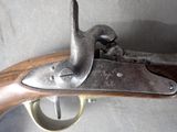 an old gun with a wooden handle on a gray surface