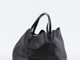 un sac fourre-tout en cuir noir sur fond blanc