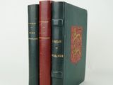 trois livres sont empilés sur une surface blanche