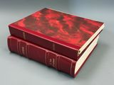 two red books sitting on top of each other on a table