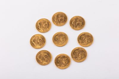 un groupe de pièces d'or sur une surface blanche