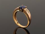 a gold ring with a sapphire stone and diamonds