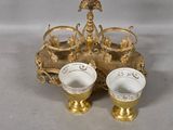 two cups sitting on a tray with gold decorations on it