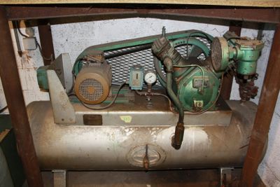 an old air compressor sitting on top of a wooden table
