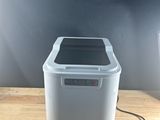 an image of a small white trash can sitting on top of a wooden table