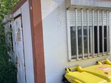a yellow trash can sitting outside of a building