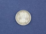 a close up of a silver coin on a blue cloth