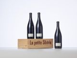 three bottles of wine sit in front of a wooden box