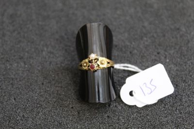une image représentant une bague en or sertie d'une pierre rouge