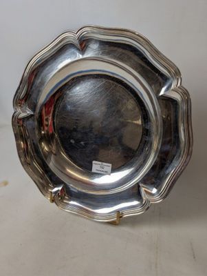 an antique silver plate with a flower design on the rim