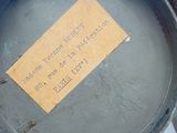 a teddy bear that is holding a pan with a label on it