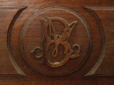a wooden chest with a carved monogram on it