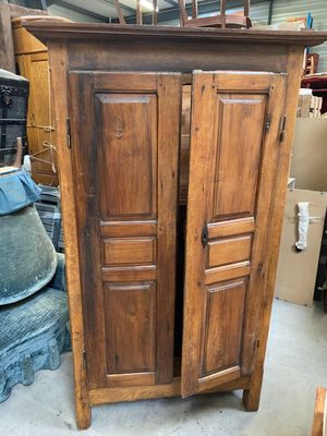 a wooden cabinet that is sitting in the middle of a pile of boxes