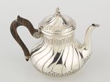 a silver teapot with a wooden handle on a white surface