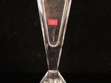 a clear glass vase with a red label on it