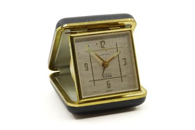 une petite horloge carrée posée sur une table