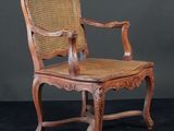 une vieille chaise en bois avec une assise en osier, sur fond noir