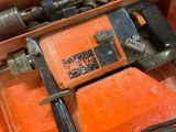 an orange box with a drill and other tools in it