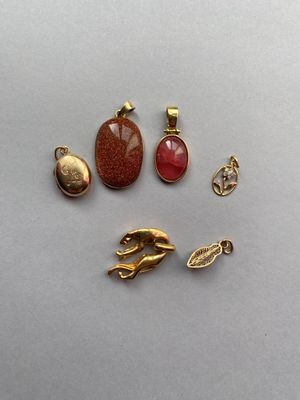 trois breloques dorées et un pendentif en forme de patte de chat