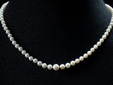 un gros plan d'un collier de perles blanches sur un mannequin