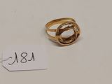 une image d'une bague en or sur une surface blanche avec une étiquette de prix