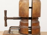 an old wooden clamp with a wooden base on a table