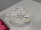 a glass bowl sitting on top of a table next to a red object