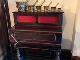 une photo d'une pièce avec un piano sur lequel sont posés des pots