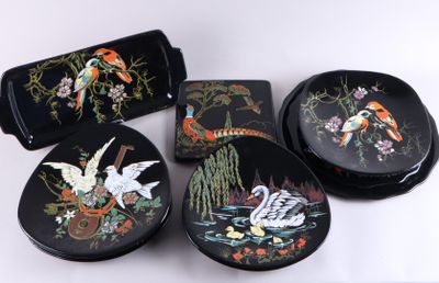 quatre boîtes noires ornées d'oiseaux et de fleurs, posées sur une table