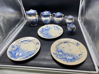 des assiettes et des tasses bleues et blanches exposées dans une vitrine