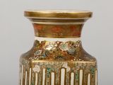 a gold vase with a floral design on it