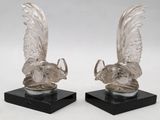 paire de figurines de dindes en verre transparent posées sur des socles en marbre noir