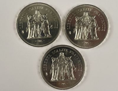 trois pièces d'argent sur lesquelles figurent l'effigie d'un homme et d'une femme