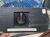 a person holding a miniature picture of a person in a room