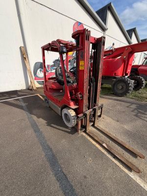 a red fork lift truck parked in front of a building