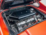 a small engine in the engine bay of an orange car