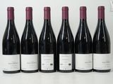 six bouteilles de vin sont alignées sur une table