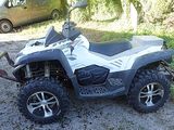 a white and black four wheeler atv parked on the gravel