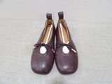 pair of brown leather shoes with a bow on the toe