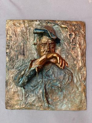 sculpture en bronze représentant un homme coiffé d'un chapeau, la main posée sur le menton