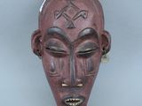 une image représentant un masque en bois orné d'une croix